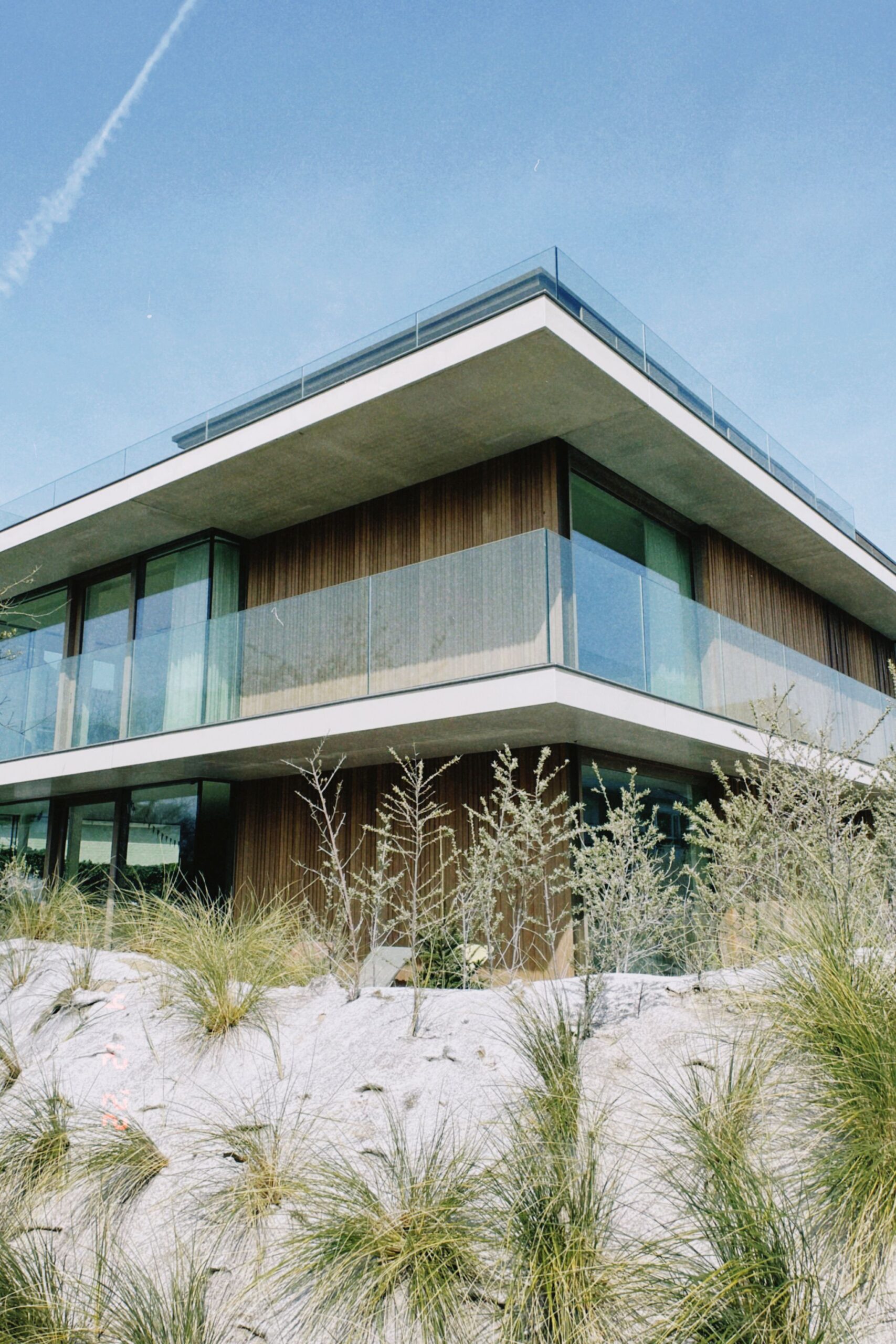 Contemporary villa featuring glass balconies and unique desert-inspired landscaping.