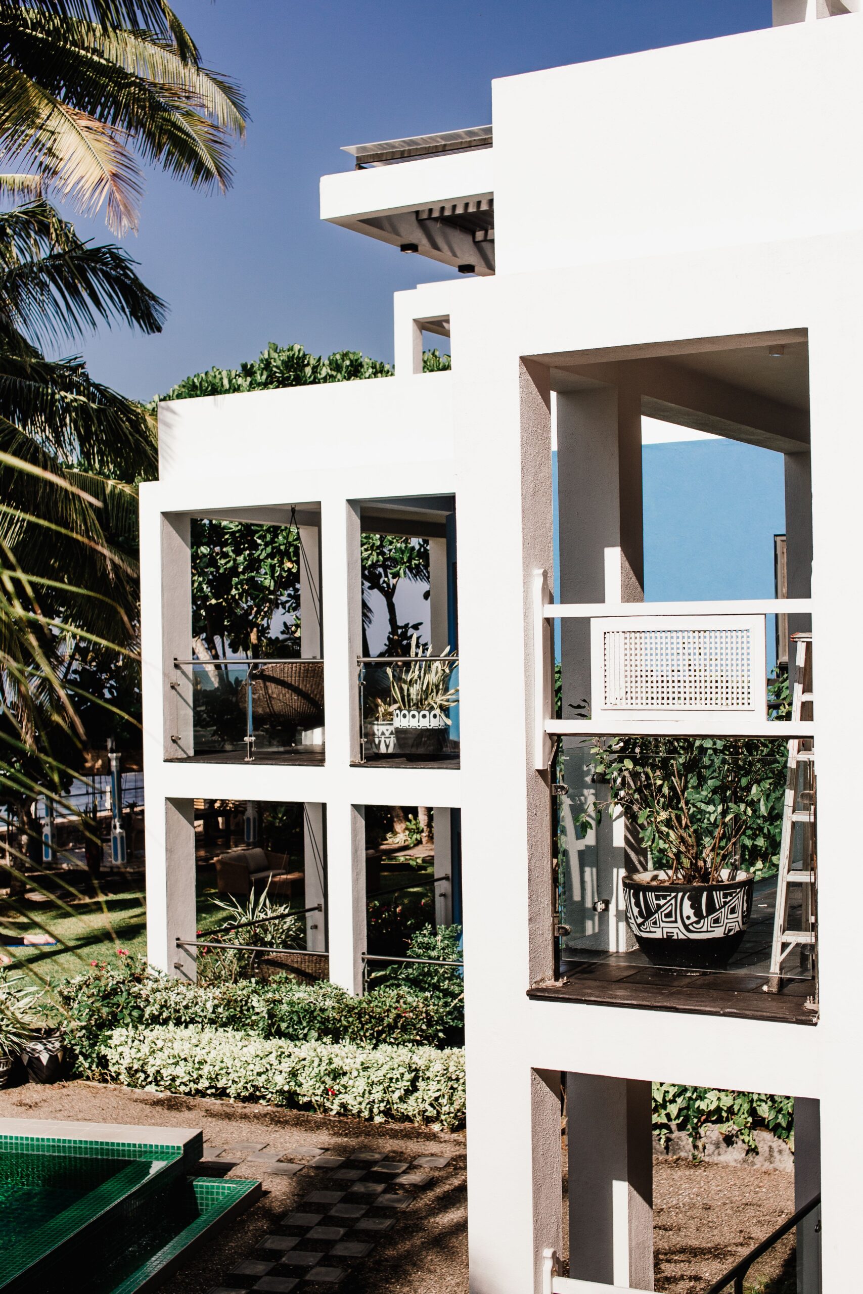 Elegant luxury resort featuring modern balconies surrounded by lush tropical gardens.